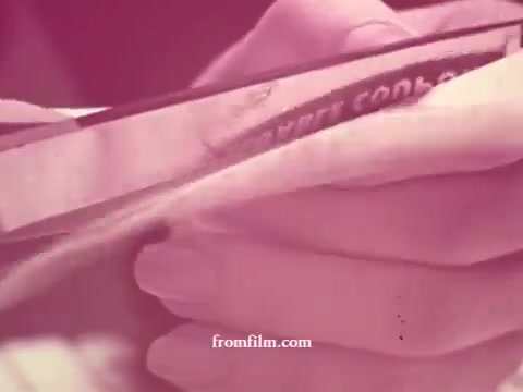 This 16mm still from 'Chatham Supermarket Commercials' features a close-up of hands holding a coupon, emphasizing shopping themes. The context suggests a focus on various grocery items such as apples, bananas, and meats, highlighting promotions and the shopping experience in a supermarket setting. The overall tone is nostalgic, reflecting the visual style of classic commercials.