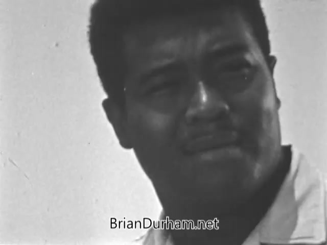 The still from the 'Volunteers in Service To America PSA - 1960s' features a close-up of a man with a contemplative expression. His furrowed brow and slightly pursed lips suggest a serious or reflective moment, emblematic of the challenges faced during the War on Poverty. The black-and-white format highlights the earnestness of the VISTA program, which aimed to mobilize volunteers in the fight against poverty and improve communities across the United States.