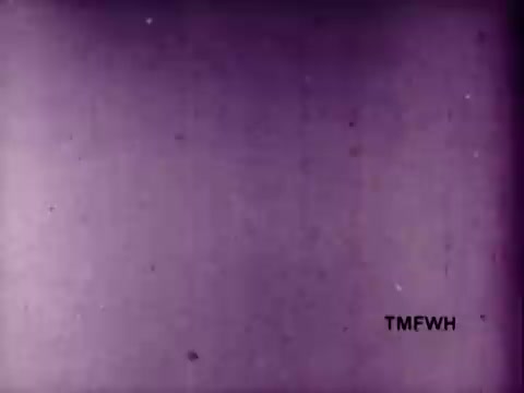The still features a muted purple background with a textured surface, giving it a vintage appearance commonly seen in older film materials. The bottom right corner is marked with 'TMFWH,' which might indicate the source or production tag. Overall, it conveys a nostalgic feel typically associated with mid-20th century advertisements.