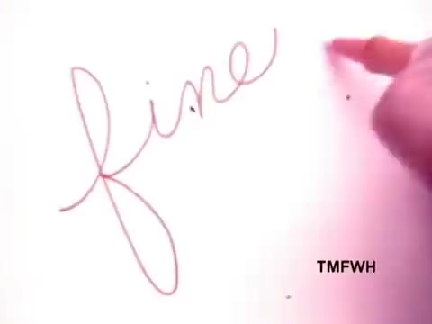 The still shows a close-up of a hand using a Flair Pen to write the word 'fine' on a piece of paper. The handwriting is smooth and flowing, emphasizing the pen's ability to create fine lines. The background appears light, creating a focus on the writing action.