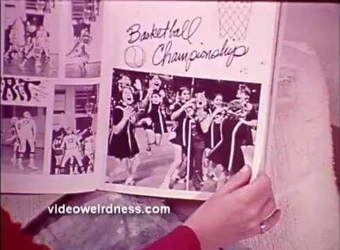 The still features a hand holding an open scrapbook with a visible page titled 'Basketball Championship.' It showcases a group of cheerleaders celebrating, likely during a basketball event. The visuals suggest a nostalgic or celebratory context, possibly emphasizing community and involvement, aligning with the mission of the Better Hearing Institute to promote awareness about hearing health.