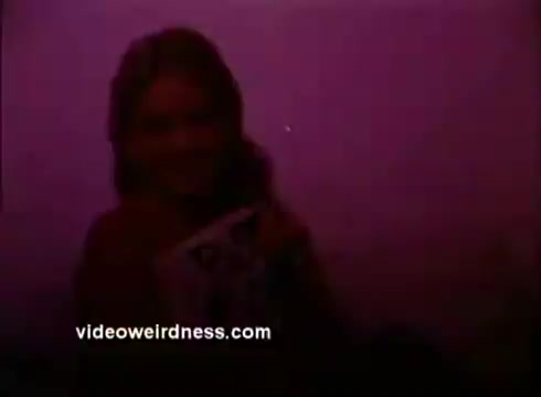 The still from the 'Hearing PSA' features a young woman with long hair, partially obscured by low lighting that creates a purple hue. She appears to be holding a magazine or pamphlet, possibly related to hearing awareness. The focus is soft, emphasizing a warm, inviting scene, likely intended to convey a personal connection to hearing health.