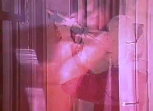 The still from 'Welcome to Fulton St' features a blurred scene where an individual appears to be interacting with a door, perhaps preparing it for energy efficiency modifications. The colors are soft and somewhat washed out, contributing to a dreamlike quality. This PSA likely promotes the benefits of upgrading to energy-efficient homes, using visual elements to convey a sense of action and transformation.