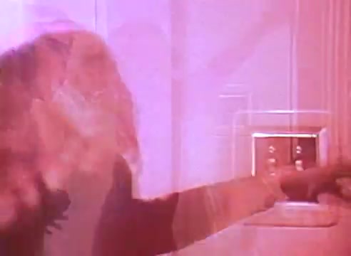 The still from 'Welcome to Fulton St' features a person interacting with a light switch, emphasizing energy conservation. The image has a soft focus and a warm, reddish hue, creating a sense of warmth and comfort associated with energy-efficient living. The moment captures a simple yet impactful action, promoting awareness about energy efficiency in homes.