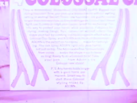 The still features a vintage advertisement for Adorn Hairspray, prominently displaying the word 'COLOSSI' in bold lettering. The background contains text promoting the product’s benefits, emphasizing its effectiveness in hairstyling. Accompanying visuals include elongated hairstyling tools, likely intended to suggest the ease of use and styling options offered by the hairspray. The overall aesthetic is characteristic of retro commercial standards, with a slightly faded color palette.