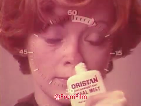 The still features a woman applying Dristan nasal mist. She has short, styled hair and an expression of focus. A circular timer graphic overlays the image, indicating time progression. The color scheme suggests a vintage aesthetic typical of 1970s advertisements. The emphasis is on demonstrating the product's ease of use for nasal relief.
