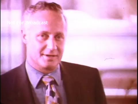 The still features a man in a suit, likely addressing the viewer, indicative of a professional or authoritative setting. His expression appears serious yet approachable. The background is blurred, suggesting a focus on the speaker. The color palette is warm, typical of 1970s film, enhancing the nostalgic feel. This image likely serves to promote awareness of the Job Corps program and its benefits during that era.