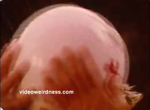 The still from the 'Red Cross PSA' features a close-up of hands delicately holding a round, pinkish balloon. The texture appears soft, and the background is blurred, drawing attention to the balloon. The overall mood suggests care and attention, likely conveying a message of safety or compassion in line with the Red Cross's mission.