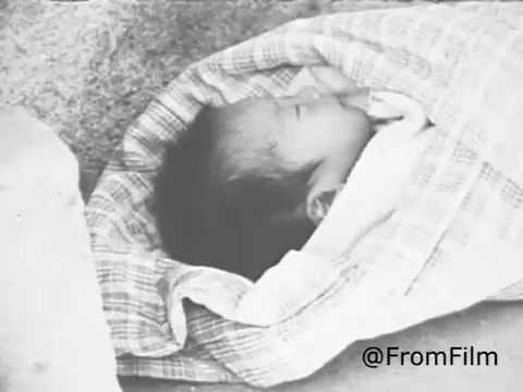 The still from the 1969 Christian Children's Fund Public Service Announcement features a close-up of a newborn baby wrapped in a patterned blanket. The focus on the infant emphasizes vulnerability and innocence, aligning with the PSA's message of support for children in need. The overall tone suggests a heartfelt appeal for compassion and assistance through child sponsorship and community programs.