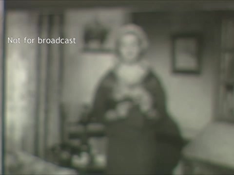 The still from the 'Support Your Mental Health Association PSA' is noticeably out of focus, which affects the clarity of the image. A figure appears to be standing in the foreground, likely delivering a message related to mental health awareness. The room's setting includes elements like furniture and decorations, but details are difficult to discern due to the blur. A watermark indicates that the image is not for broadcast, suggesting it's meant for archival or private viewing. Overall, the frame captures a moment from a bygone era, emphasizing the importance of mental health in a public service context.