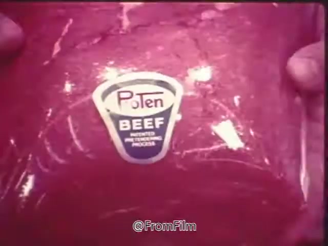The still from the 1970s Swift Pro-Ten Tenderized Beef commercial features a close-up of a packaged cut of beef, prominently displaying the 'ProTen BEEF' label. The labeling emphasizes the process of tenderization. The image captures the product's vibrant red color, suggesting freshness. The commercial likely concludes with a voice-over promoting the availability of ProTen beef at local grocery stores, such as A&P.