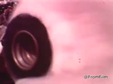 The still features a close-up of a large racing tire, likely from a dragster, with smoke billowing around it, indicating a high-speed launch or burnout. The context suggests it's part of a car maintenance PSA featuring drag racing legend Don Garlits discussing the importance of car maintenance for competitive racing.   As for the Dodge in the video, it could originate from the 1960s based on the era of the footage. However, without specific details about the model, it's challenging to pinpoint the exact year.