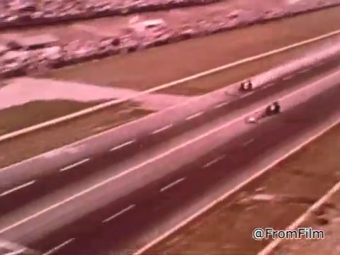 The still from 'Dragsters and Cars' features a drag racing scene, likely from the 1960s, showcasing cars racing on a strip. Don Garlits, a renowned drag racer, discusses the importance of maintaining a car in top condition for winning races. The Dodge in the image could be from the same era, possibly in the mid to late 1960s, but exact identification requires more specific details about the model.