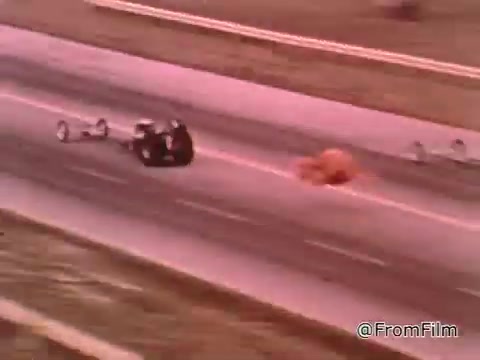 The still features a drag racing scene from the 1960s, showcasing high-performance cars competing on a track. Don Garlits, a prominent figure in drag racing, is discussing the importance of car maintenance for winning races. The Dodge in question likely dates from the 1960s, a period marked by iconic muscle cars, but a specific year can't be determined without more context.