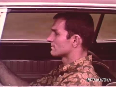 In the still from the PSA featuring Don Garlits, we see him sitting inside a car, likely a Dodge, which aligns with the context of drag racing and car maintenance. The scene captures a moment focused on the driver, emphasizing the importance of both skill and vehicle condition for winning drag races. The clothing style suggests it is from the 1960s, which corresponds with the video's time period. For a more specific year for the Dodge, additional details about the car's model and features would be needed.