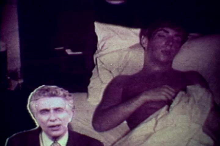 The still features a somber scene from the anti-drug film *Drug Abuse: Some Comments from the Morgue*. At the forefront is Tillman Hahn, speaking directly to the audience, while a young man lies on a bed in a vulnerable state, partially covered by sheets. The overall tone conveys the serious consequences of drug abuse, emphasizing both the human cost and the educational message aimed at deterring substance use. The visual style reflects the era's documentary aesthetics, utilizing stark imagery to provoke thought and awareness.