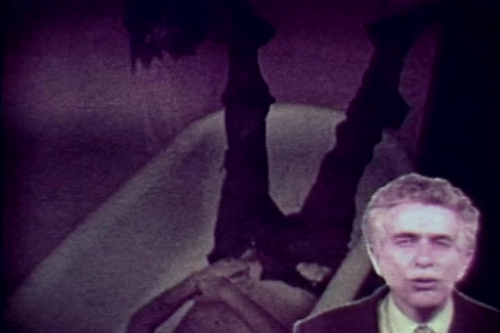 The still from 'Drug Abuse: Some comments from the morgue' features a somber scene where a victim is depicted upside down in a bathtub, suggesting the grim realities of drug abuse. In the foreground, Tillman Hahn, representing the Medical Examiner's office, speaks directly to the camera, likely delivering a cautionary message. The overall tone emphasizes the tragic consequences of drug addiction, aligned with the film's anti-drug message from the 1970s. The visual composition combines a stark, unsettling image with an authoritative voice, creating a powerful commentary on the issue.