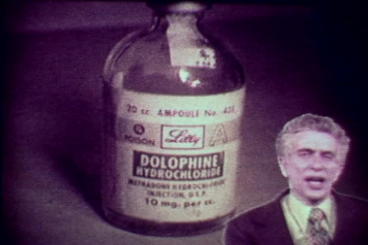 The still features a close-up of a glass ampoule labeled 'DOLPHINE HYDROCHLORIDE,' indicating it contains methadone, a medication often associated with drug treatment. The foreground includes a man, presumably Tillman Hahn, delivering a commentary. The visual style, characteristic of 1970s anti-drug films, emphasizes the seriousness of drug abuse and its consequences. The tone is educational, warning against the dangers associated with drug use.