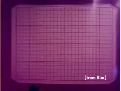 The still from the film 'Bell System - Preventing Data Transmission Errors' (1967) depicts a blank oscilloscope screen, marked by a grid pattern. The background is characterized by a pinkish hue, which may suggest a lab defect or color processing issue. This still captures a moment likely related to the analysis of data transmission, serving as a visual cue for the film's focus on technology and error prevention in communications.