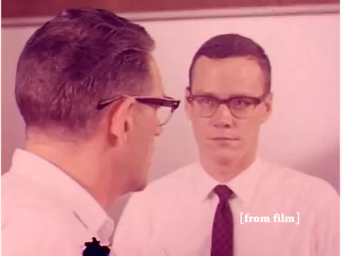 The still from the Bell System film 'Preventing Data Transmission Errors' features two men engaged in a serious conversation. One man, wearing glasses and a white shirt, faces another man in a striped tie, both appearing focused on the discussion. The scene likely emphasizes the collaborative effort in addressing technological issues related to data transmission. The film's focus on engineers and technology aligns with its subject matter, though the quality may be affected by the lab defect noted in the paperwork.