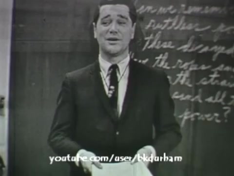 The still from '6th Grade Linguistics (1966)' features a man, likely a teacher, standing in front of a chalkboard. He appears expressive while holding papers, suggesting he might be engaged in a lesson or discussion. The visual quality resembles that of a kinescope, capturing the vintage aesthetic typical of educational films from the era. The handwriting on the chalkboard adds to the educational context, indicating a focus on language or grammar.