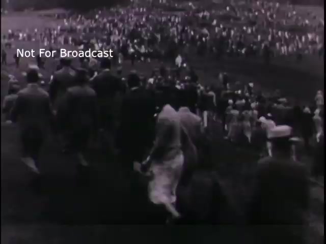 The still from 'US Army recruiting - 'Join the new action army'' depicts a large crowd of people, possibly rallying or attending an event related to military recruitment in the 1960s. The black-and-white imagery suggests a historical context, emphasizing the era's recruitment efforts and the community's involvement. The text 'Not For Broadcast' indicates that this footage is not intended for public airing. Overall, it captures a moment of collective action and interest in military service from that time.