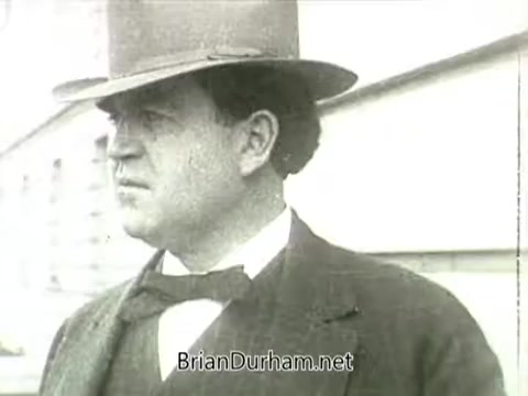 The still features John L. Lewis, a prominent labor leader, captured in a serious expression while wearing a formal suit and a wide-brimmed hat. The background is indistinct, focusing attention on his figure. The image is part of historical newsreel footage, depicting the labor struggles during the 1919 Miners' Strike in the United States.