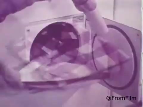The still from the 1960s Rinso Detergent commercial showcases a person pouring detergent into a washing machine. The vibrant colors highlight the product's new feature, Color Bleach, promising effective cleaning without fading colors. The vintage aesthetic reflects the era's advertising style, emphasizing innovation and household convenience.  for more!
