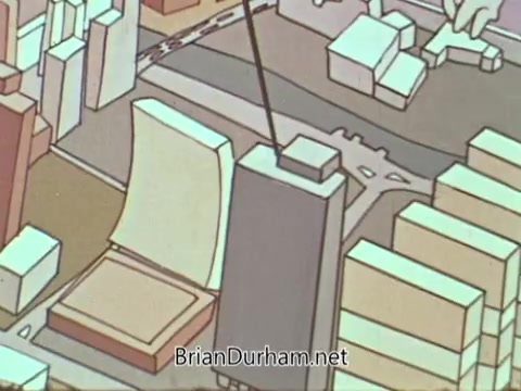The still from the 'American Hospital Association PSA' features an animated representation of a cityscape. It showcases various geometric buildings, with a focus on a prominent structure resembling a hospital. A line or pointer indicates a specific location on the map, emphasizing its significance within the context of healthcare services. The style is colorful and simplistic, aligning with the educational tone of a public service announcement.