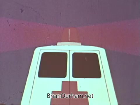 The still features the rear view of an ambulance, with its red cross symbol prominently displayed. The backdrop comprises vibrant colors, creating a striking contrast to the white vehicle. This visual is likely part of a public service announcement (PSA) promoting awareness or support for hospitals and healthcare services.