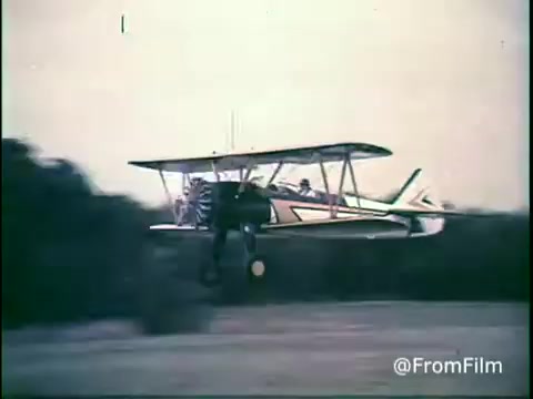 The still shows a biplane flying above a grassy field, possibly emphasizing adventure or nostalgia. The muted colors and vintage aesthetic reflect the 1970s style in advertising, fitting for a Kellogg's Shredded Wheat commercial. The scene likely conveys a sense of wholesome fun and freedom associated with the product.