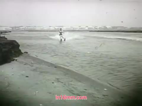 The still from the 1968 trailer of 'Out Of It' features a figure skiing on water, likely set against a coastal backdrop. The scene captures a vintage, nostalgic aesthetic characteristic of the era, emphasizing a sense of adventure and leisure. The overall tone suggests a quirky, lighthearted approach typical of late '60s cinema.