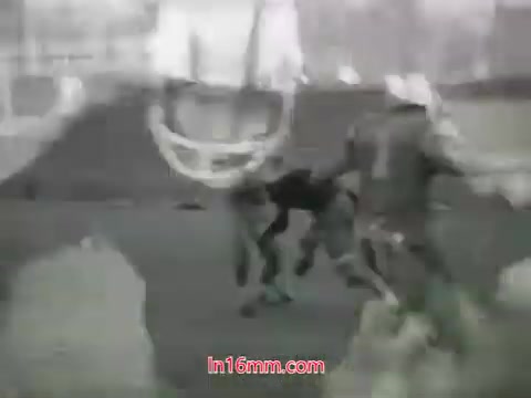 The still from the 1968 trailer for 'Out of It' features a dynamic scene likely capturing a football game or practice. Figures in athletic gear are engaged in action, creating a sense of movement and intensity. The image is in black and white, adding a classic, nostalgic feel that emphasizes the period's style. Overall, it conveys a youthful energy typical of 1960s cinema.