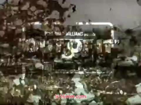 The still from the trailer of 'Out Of It' (1968) features a distinctive, vintage aesthetic typical of 16mm film, with grain and texture that evoke a nostalgic atmosphere. The title is prominently displayed, likely framed by scenes or imagery related to the film. The overall visual suggests a blend of drama and youthful themes, reflecting the era's cinematic style.