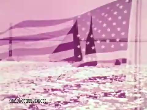 The still from the 'Freedoms Foundation PSA with Anita Bryant - 1968' features a serene scene of an American flag gently waving over rippling water. The colors convey a soft, nostalgic tone, likely reflecting the era's sentiments. The accompanying voiceover by Anita Bryant references the historical significance of Valley Forge and the endurance of George Washington's army, linking the past struggles for freedom to contemporary American values. The overall message emphasizes patriotism and unity.