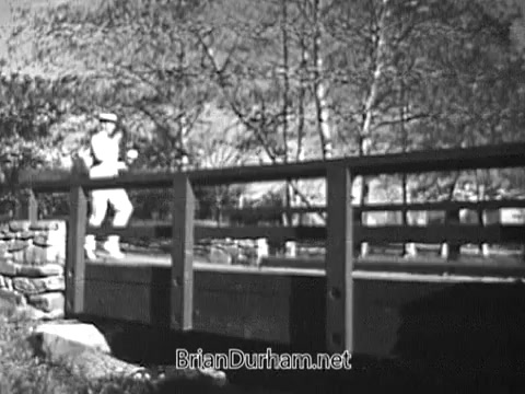 The still features a figure jogging over a bridge in a natural setting, likely promoting an active lifestyle. The scene is in black and white, typical of vintage commercials from the late 1960s, and reflects a charming, nostalgic atmosphere associated with outdoor activities and health.
