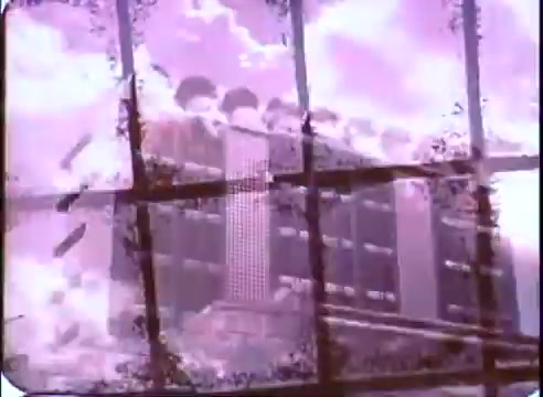 The still from 'The Time Machine' promos features a visually distorted image with a prominent structure, likely a futuristic or stylized building, viewed through a window frame. The color palette consists of purples and whites, creating a dreamlike atmosphere. The print shows signs of age, with noticeable scratches and texture, contributing to the retro aesthetic of the piece.