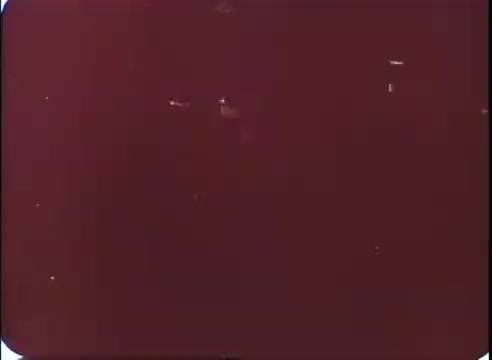 The still appears to be a faded or damaged frame from a 16mm print of promotional materials for 'The Time Machine.' The image has a reddish tint and shows some visible scratches or dust particles, indicating its age and film medium. No distinct scenes or characters are identifiable due to the quality of the print.