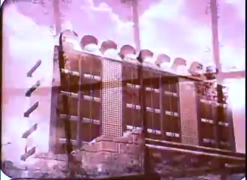 The 16mm still from the promotional material of 'The Time Machine' features a futuristic, somewhat abstract setting. The image contains elements that suggest a mix of architectural structures, possibly implying advanced technology or a dystopian environment. The use of color is predominantly pink, giving it a surreal quality. There are visible textures and patterns that create a layered effect, hinting at a blend of past and future elements, characteristic of the themes explored in the film.