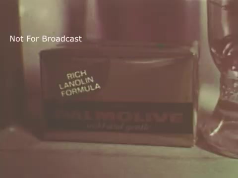 The still features a close-up of a Palmolive soap bar packaging. The box is labeled 'RICH LANOLIN FORMULA,' emphasizing its moisturizing properties. The overall presentation suggests a vintage aesthetic typical of 1970s advertisements, with muted colors and a focus on product details. A glass container is visible in the background, adding context to the setting. The overlay states 'Not For Broadcast.'