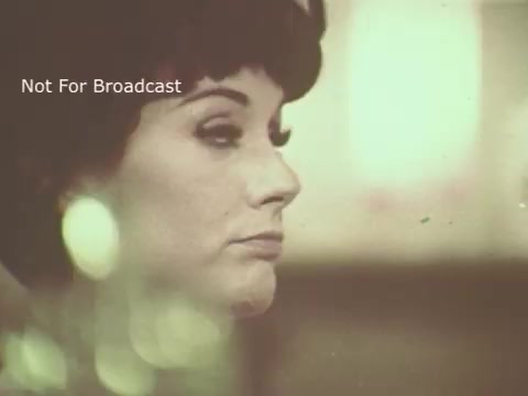 The still from the 1970s Palmolive soap commercial features a woman with a classic hairstyle, characterized by a bob cut. She has noticeable makeup, highlighting her eyes and lips. The image has a vintage aesthetic, with soft focus and slight graininess, creating a nostalgic feel. The background suggests a domestic or personal care context, typical of soap advertisements. The text 'Not For Broadcast' indicates that this is a private or archival image.