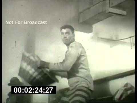 The still appears to show a black-and-white scene from a film promo associated with the ABC Sunday Night Movie from the 1960s. It features a man in a striped outfit, possibly depicting a prisoner or someone in a similar setting, holding a large object—possibly a mat or a rug. The scene conveys a sense of action or drama, typical of movie promos from that era. The timestamp and “Not For Broadcast” watermark indicate that this is likely a behind-the-scenes or archival piece meant for reference rather than public viewing.