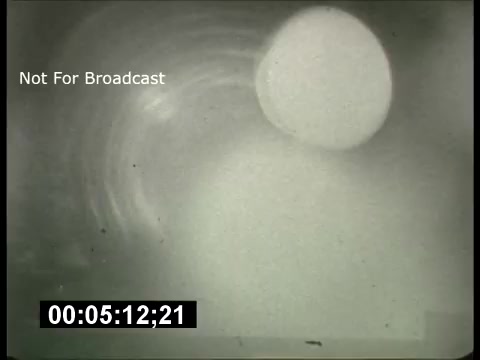 The still from the 'ABC Sunday Night Movie' promos in the 1960s features a blurred, abstract image with a circular shape and soft, swirling textures in the background. It has a vintage look, typical of the era's film quality, and includes a timecode and the note 'Not For Broadcast.' The style reflects the promotional approach of television at the time, emphasizing a distinctive visual aesthetic.