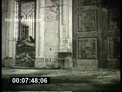 The 16mm still from the 'ABC Sunday Night Movie' promos from the 1960s features a dramatic shot of a grand entrance with ornate wrought iron gates, flanked by stone architecture. The scene captures a moody atmosphere, likely designed to build suspense or intrigue around the upcoming feature film. A timecode is visible, indicating the footage is not for broadcast, hinting at its archival nature.