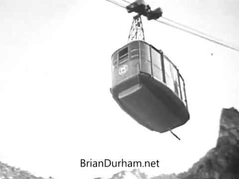 The still from the 'Rolaids Commercial - 47 times its weight in stomach acid' features a black-and-white image of a gondola or cable car suspended in the air, likely traversing a mountainous landscape. The scene captures a sense of height and tension, correlating with the product's message about relief from heavy stomach acid. The overall composition emphasizes the gondola's journey, mirroring the relief Rolaids offers in digestive discomfort.