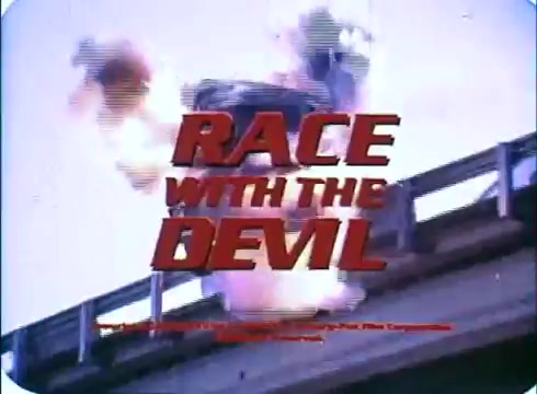 The still from the trailer of 'Race with the Devil' features a dynamic scene with vibrant colors typical of 16mm prints. The title 'RACE WITH THE DEVIL' dominates the foreground, presented in bold red letters, while an action-packed explosion is captured in the background, suggesting high-stakes drama. The image conveys a sense of urgency and excitement, typical of thriller genre trailers from its time.