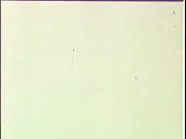 The 16mm still appears to be a blank or lightly marked frame, typical of leader tape from film reels. It's likely intended for use in editing or transitioning between segments, with minimal visual information and some minor scratches or marks, which are common in older film materials. The context suggests it's related to transferring commercials, possibly for archival or editing purposes.