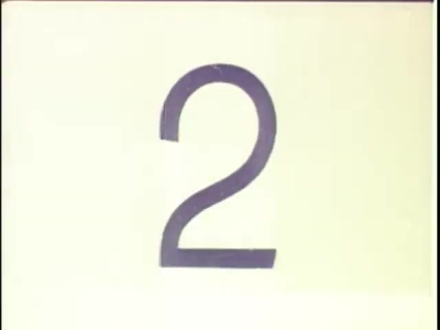 The still features a large, stylized numeral '2' against a light, possibly white background. The design is simple and clean, characteristic of leader used in film and video production. This specific frame likely serves as a visual cue within a sequence, typical for setting up transitions or indicating segments in tape-to-film transfers.
