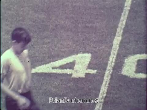 The still from the 1967 PSA by the President's Council on Physical Fitness shows a young boy walking on a grassy field marked with a large number '40.' The scene captures a moment focused on promoting physical fitness, likely in a sports or exercise context. The image conveys a sense of activity and engagement with physical health.