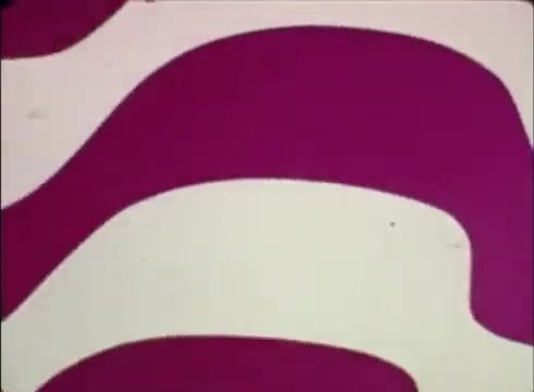 The still from the 16mm print of 'Job Service Nebraska - Book Store' features bold, swirling patterns in contrasting colors, primarily in shades of pink against a lighter background. This design likely aims to capture attention and convey a retro feel typical of promotional material from that era. The patterns could suggest creativity and dynamism, aligning with the theme of job services and opportunities in the bookstore context.